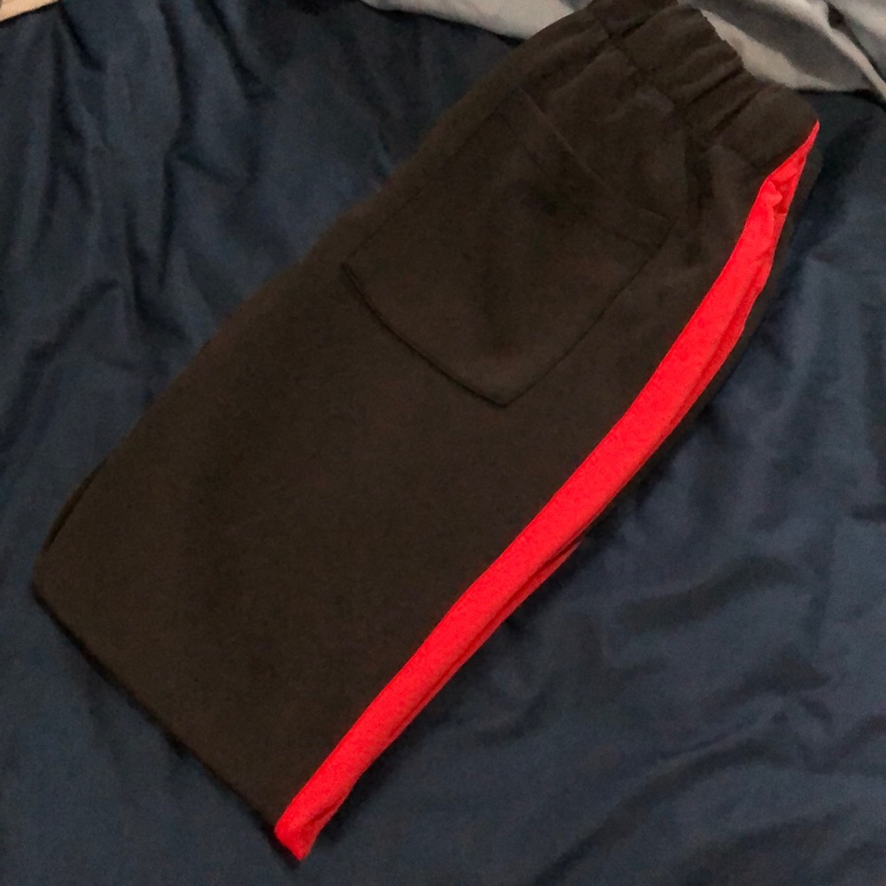 Black track pants with red stripe